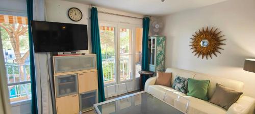 un salon avec un canapé et une télévision à écran plat dans l'établissement Nice family studio near the beach Fréjus, à Fréjus