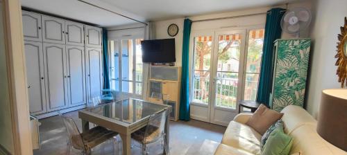 un salon avec un canapé et une table en verre dans l'établissement Nice family studio near the beach Fréjus, à Fréjus