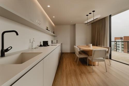 a kitchen with a wooden table and a dining room at Seissta Medellín in Medellín