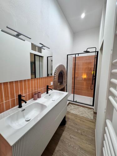 une salle de bain avec deux lavabos et une douche dans l'établissement A Casa Grandval - Ajaccio, à Ajaccio