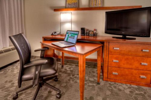 a desk with a laptop and a chair in a hotel room at Courtyard by Marriott Burlington in Burlington
