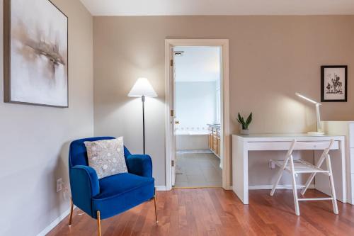a living room with a blue chair and a desk at Spacious & Serene 6-Br Family Retreat in Kirkland in Kirkland