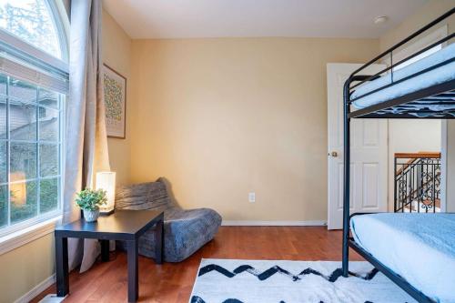 a bedroom with a bed and a couch and a table at Spacious & Serene 6-Br Family Retreat in Kirkland in Kirkland