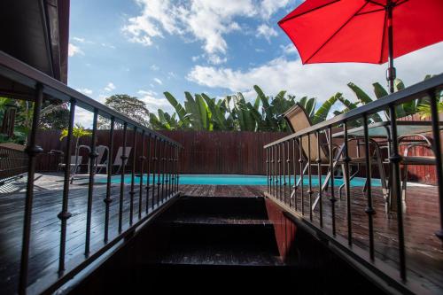 a patio with a red umbrella and chairs and a pool at Quinta Issazu in Juntas