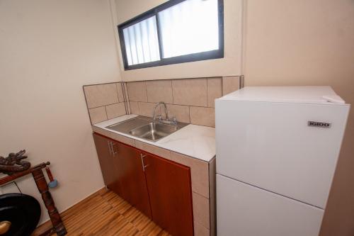 a small kitchen with a sink and a refrigerator at Quinta Issazu in Juntas