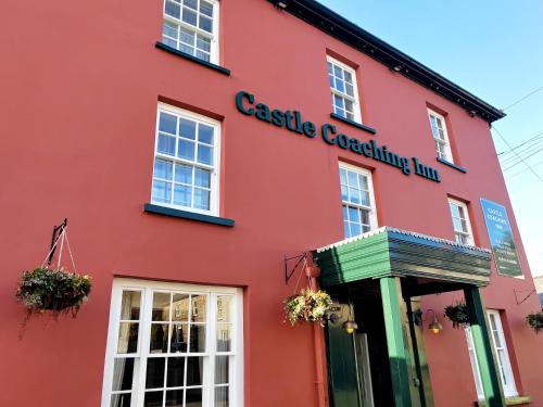 a red building with the words castle coaching inn at The Castle Coaching Inn in Trecastle
