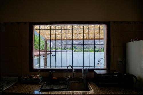 a kitchen with a large window over a sink at Casa en el corazón de Huacalera, Jujuy in Tilcara