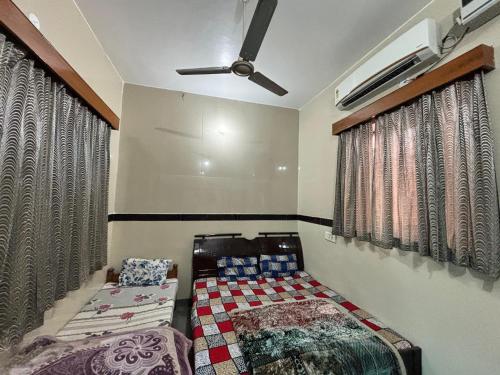 a bedroom with a bed and a ceiling fan at Shri Gaya Prasad Dham in Vrindāvan