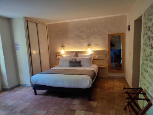 a bedroom with a large bed with white pillows at Le Mas des Laurels in Chantemerle-lès-Grignan