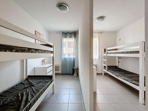 une chambre avec trois lits superposés et une fenêtre dans l'établissement 3356-Appartement 8 couchages, à Argelès-sur-Mer