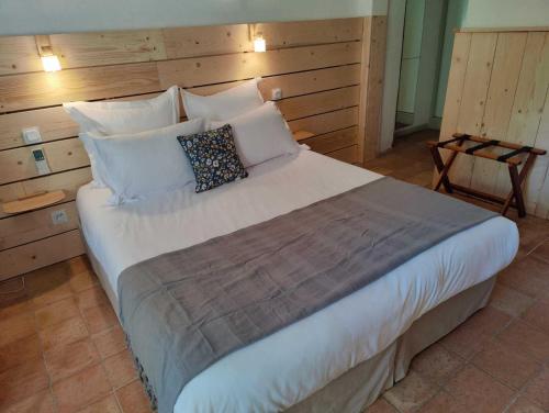 a bedroom with a large bed with white pillows at Le Mas des Laurels in Chantemerle-lès-Grignan