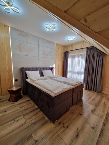 a bedroom with a large bed in a room with wooden floors at Chata Braci Warchały in Warchały