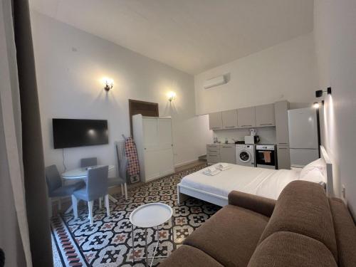 a hotel room with a bed and a table and a couch at The Old Mint Residence 4 in Valletta