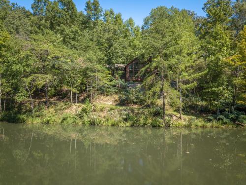 a cabin in the woods next to a lake at Reflections in Sevierville