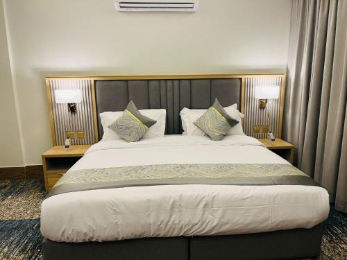 a large bed in a hotel room with two lamps at فندق سفن دريم in Al Kharj
