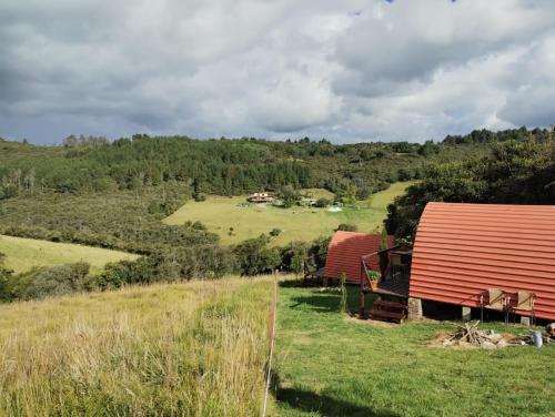 GachancipáにあるGlamping La Guadalupanaの野地の赤納屋二軒の眺め
