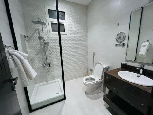 a bathroom with a shower and a toilet and a sink at فندق سفن دريم in Al Kharj
