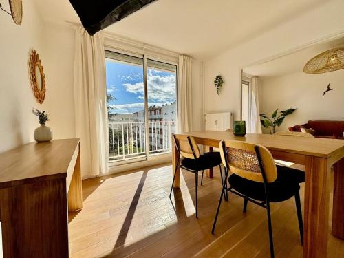 une salle à manger avec une table et des chaises et une fenêtre dans l'établissement Le Cocon Méditerranéen, à Béziers