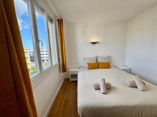 une chambre avec un lit avec deux serviettes dessus dans l'établissement Le Cocon Méditerranéen, à Béziers