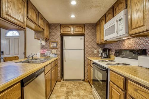 a kitchen with wooden cabinets and a white refrigerator at BlackBerry Ridge in Pigeon Forge