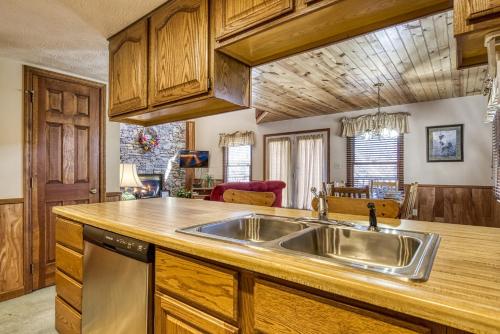 a kitchen with a stainless steel sink and wooden cabinets at BlackBerry Ridge in Pigeon Forge