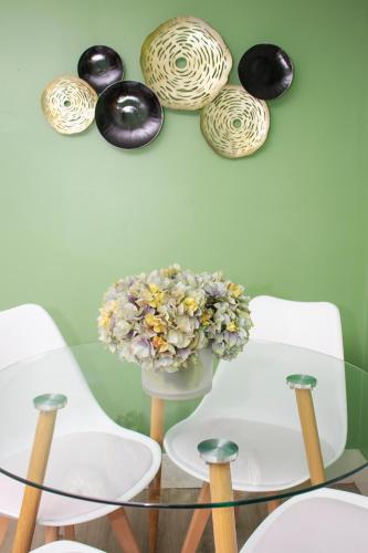 a glass table with a vase of flowers on a wall at Exceptional & Central, Garden Suite, Top Amenities & Care! in Central Islip