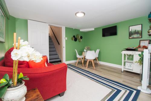 a living room with green walls and a red chair at Exceptional & Central, Garden Suite, Top Amenities & Care! in Central Islip