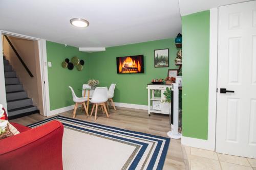 a living room with green walls and a red couch at Exceptional & Central, Garden Suite, Top Amenities & Care! in Central Islip