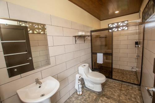 a bathroom with a toilet and a sink and a shower at Quinta Issazu in Juntas