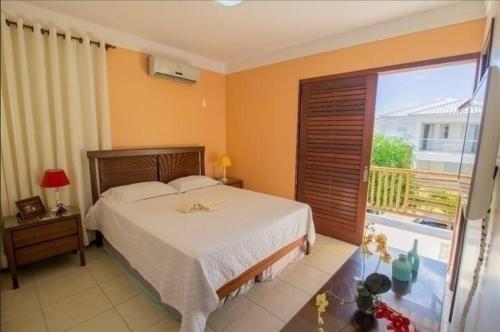 a bedroom with a bed and a large window at Casa de Praia em Guarajuba-Genipabu-BA in Guarajuba