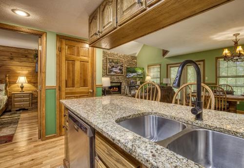 a kitchen with a sink and a living room at Grandpas Getaway in Pigeon Forge