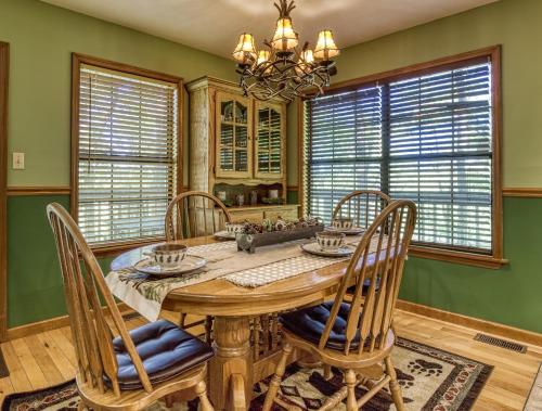 a dining room with a wooden table and chairs and green walls at Grandpas Getaway in Pigeon Forge