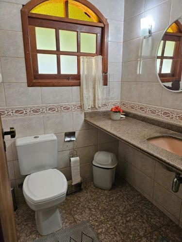 a bathroom with a toilet and a sink and a mirror at Sítio Bem Querer in Lagoa Santa