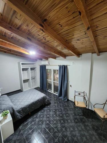 ein Schlafzimmer mit einem Bett und einer Holzdecke in der Unterkunft Departamento centro Maipú Mza, sobre ruta del vino, equipado para 4 personas in Maipú