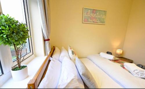 a bedroom with a bed with pillows and a window at Private Bliss Near Luton Station in Luton