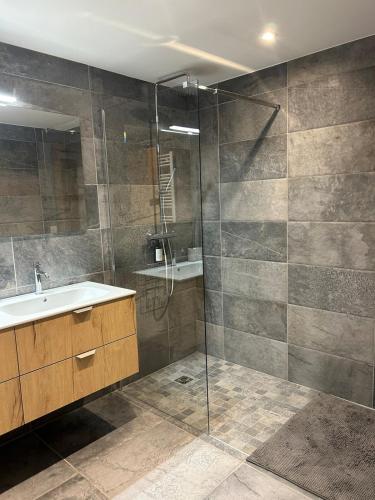 une salle de bain avec un lavabo et une douche en verre dans l'établissement Chalet Angelus - Appartement neuf 3 chambres Grand Bornand, à Saint-Jean-de-Sixt