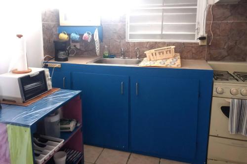 a blue kitchen with a sink and a microwave at Beachfront Suite 5 Coqui in Vieques