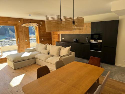 un salon avec un canapé et une table dans l'établissement Chalet Angelus - Appartement neuf 3 chambres Grand Bornand, à Saint-Jean-de-Sixt