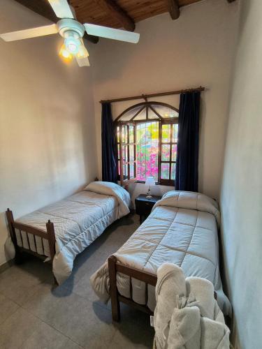 two beds in a room with a window at Departamento Santa Rita in Esquina