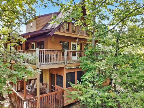 a large wooden house with a balcony and trees at Mountain Side in Pigeon Forge