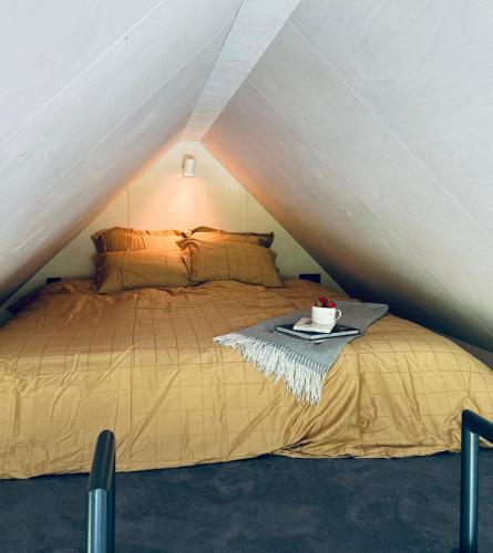 a bed in a attic with a tray with a cake on it at PAUS puhkemaja in Põõsaspea