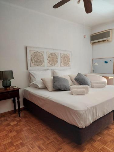 a bedroom with a large bed with white sheets and pillows at Casa Tété in Faro