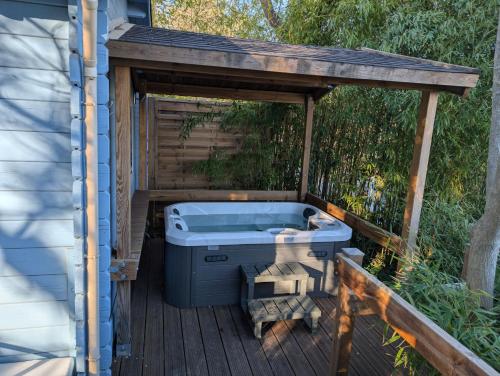 a hot tub on a deck next to a house at Le Chalet Bleu - jacuzzi in Aix-en-Provence