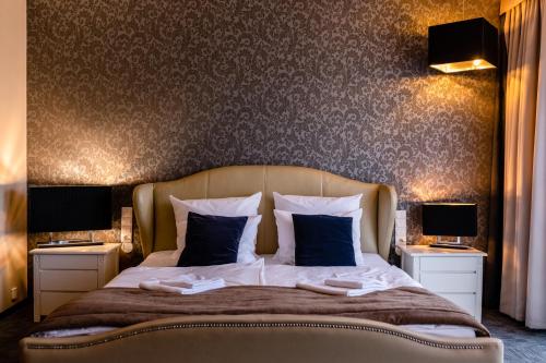 a bedroom with a large bed with two night stands at Hotel Alhar in Lubliniec