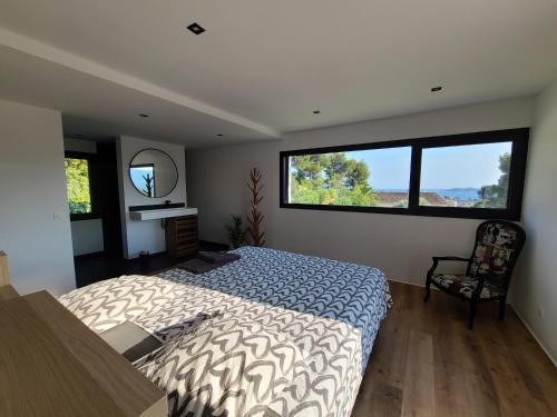 une chambre avec un lit et deux grandes fenêtres dans l'établissement Belle Villa au calme avec Piscine grands volumes à deux pas des plages de La Ciotat, à La Ciotat