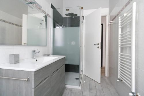 a white bathroom with a sink and a shower at Ele's apartment in La Spezia