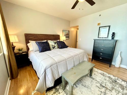 a bedroom with a large bed and a black dresser at Amazing views! Great beachfront Panama City Condo in Panama City Beach