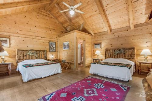 Un dormitorio con dos camas en una cabaña de madera. en The Community at Riggins Hot Springs, en Riggins