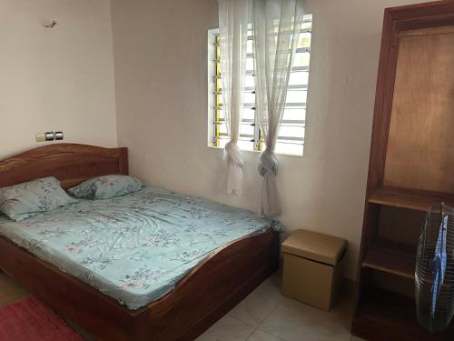 a small bedroom with a bed and a window at Maison de vacances Calavi séminaire in Abomey-Calavi