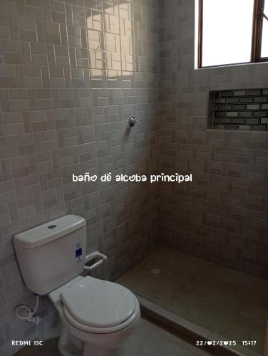 a bathroom with a white toilet and a window at Arriendo casa campestre in Tabio
